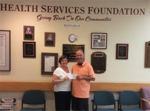 Don Collins, right, chairman of the County Open, presents a $20,000 check to Elizabeth Dulin, executive director of the Health Services Foundation.